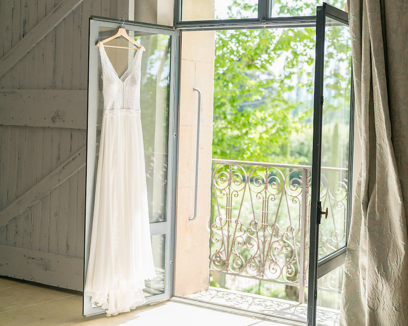 A wedding dress hung at the balcony of a wedding venue in France
