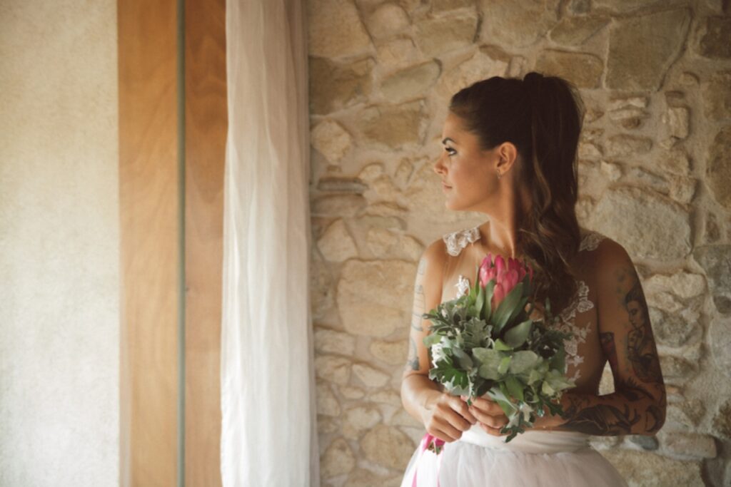 A bride looking out of the window holding a bouquet of flowers