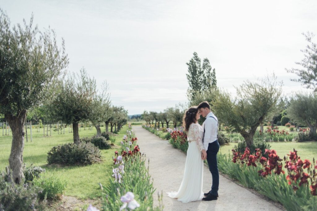 A bride and groom holding hands in bridal wear in an outdoor location in Spain