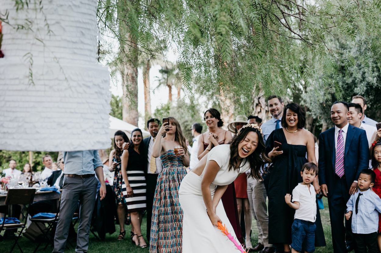 A bride laughing while taking part in a wedding day activity