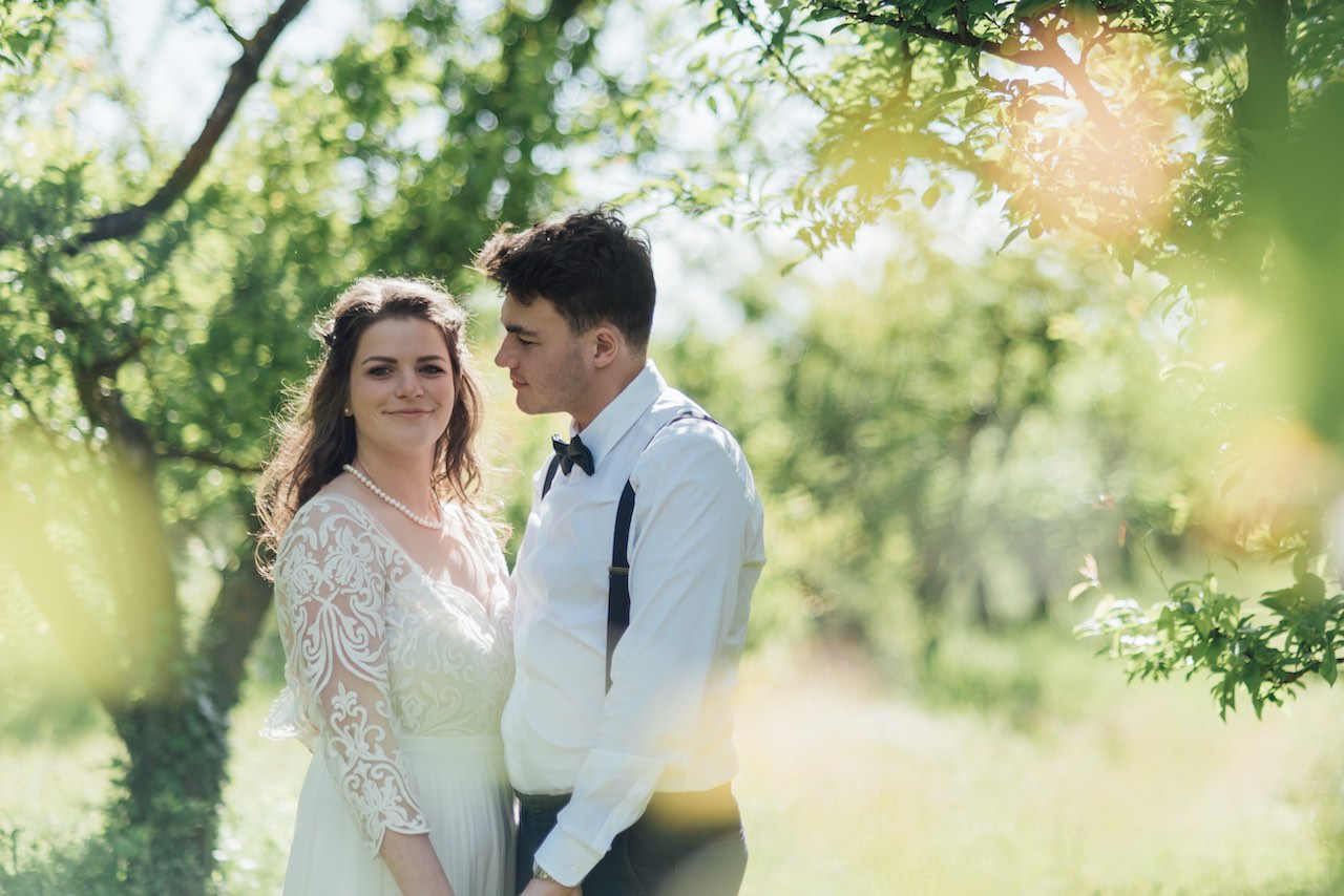 A bride and groom holding each other in a rural location