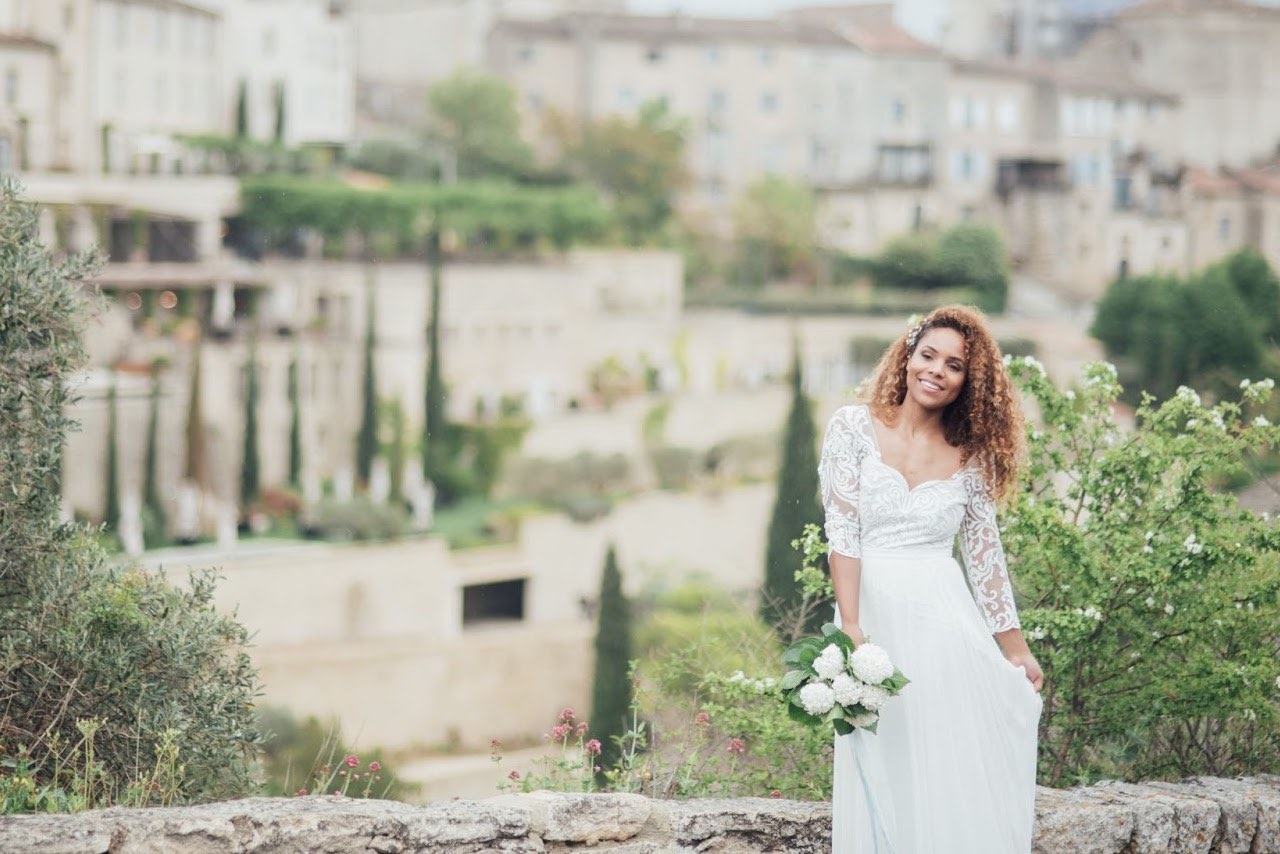 A bride in a bridal dress stood in rural Spain with a rustic Spanish town in the background A bride in a bridal dress stood in rural Spain with a rustic Spanish town in the background