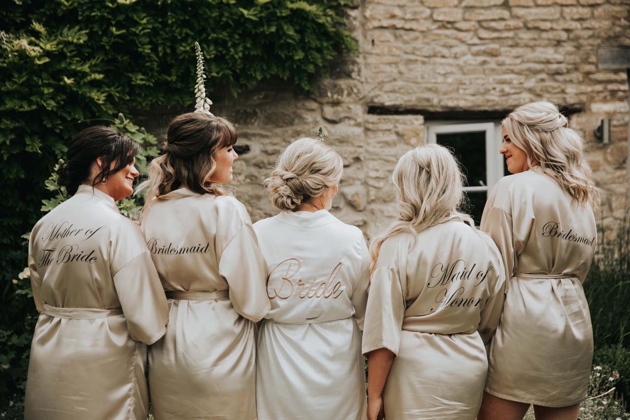 A bride, bridesmaids and maid of honour wearing robes