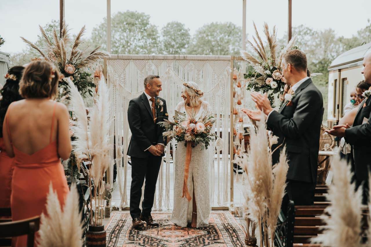 A bohemian wedding, with a macrame hanging and pampas grass