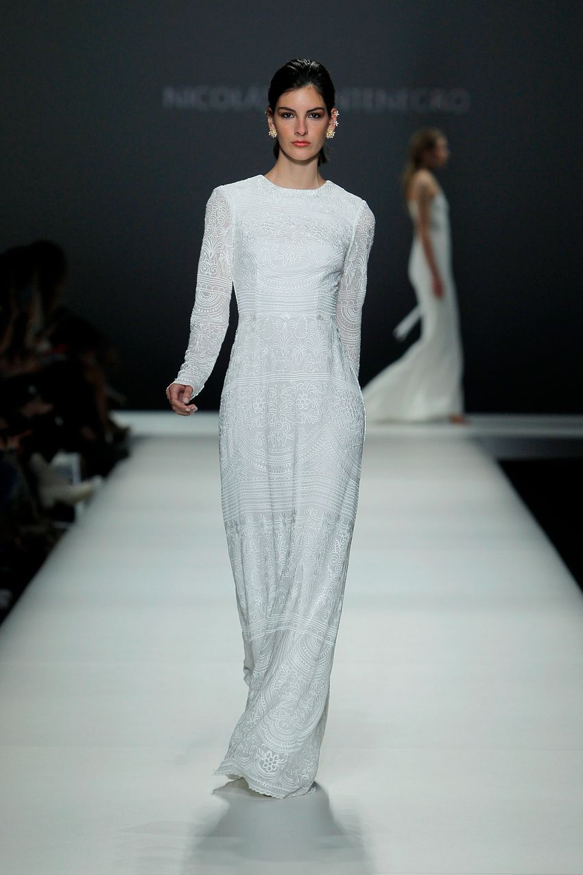 A white long floor length dress with sleeves and cuffs by Nicholas Montenegro at the Barcelona Bridal Fashion Week 2